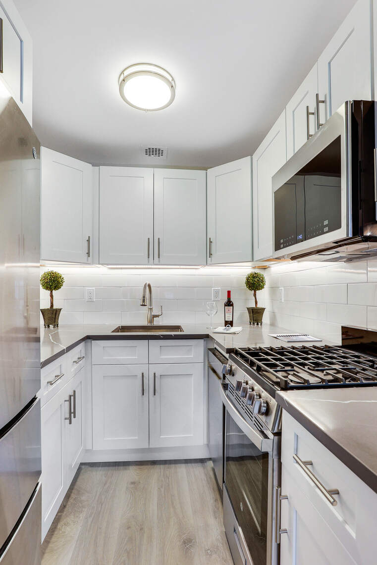 237 East 17th Street, Unit 520 Manhattan, NY 10003 - Photo 7 of 14 a kitchen with stainless steel appliances granite countertop a sink stove and cabinets