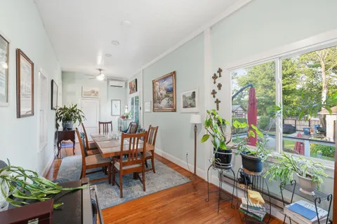 a dining room with furniture potted plants and wooden floor