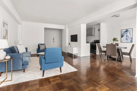 a living room with furniture and a wooden floor
