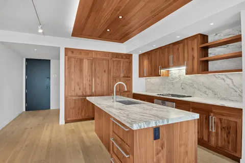 a kitchen with kitchen island granite countertop wooden cabinets a sink and dishwasher