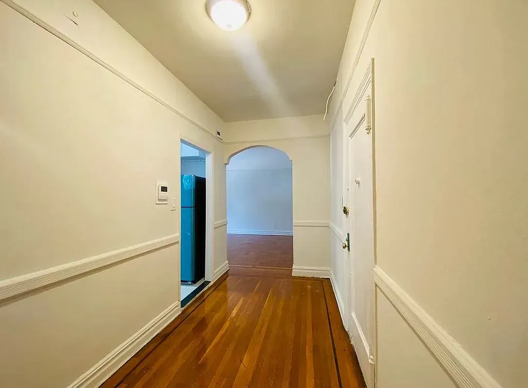 a view of a hallway with wooden floor