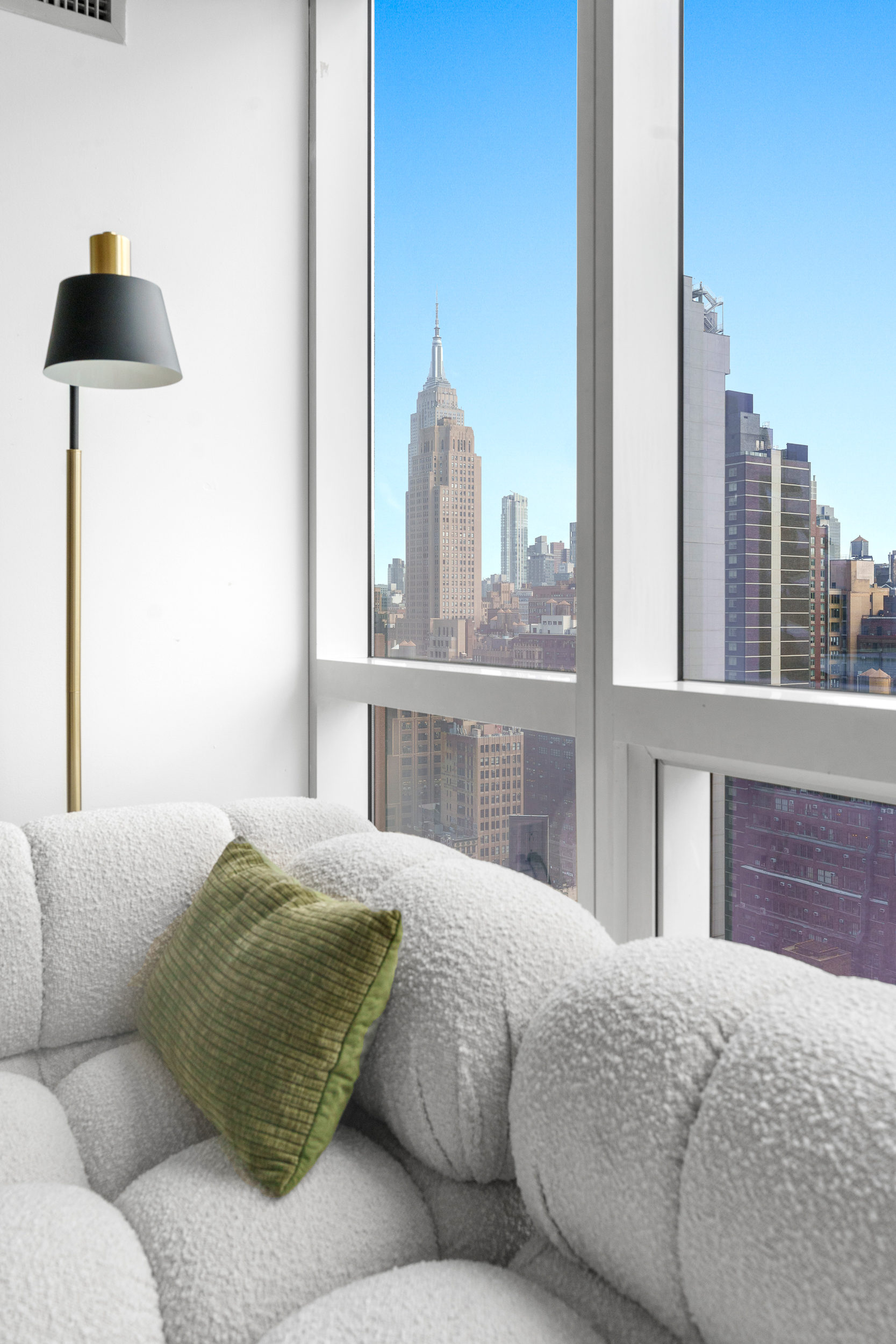 350 West 42nd Street, Unit 27K Manhattan, NY 10036 - Photo 5 of 18 a living room with a couch and a floor to ceiling window