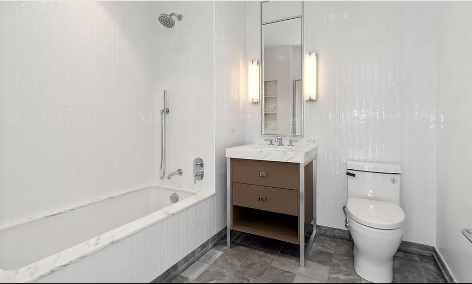 368 3rd Avenue, Unit 32B Manhattan, NY 10016 - Photo 11 of 19 a spacious bathroom with a bathtub toilet sink and mirror