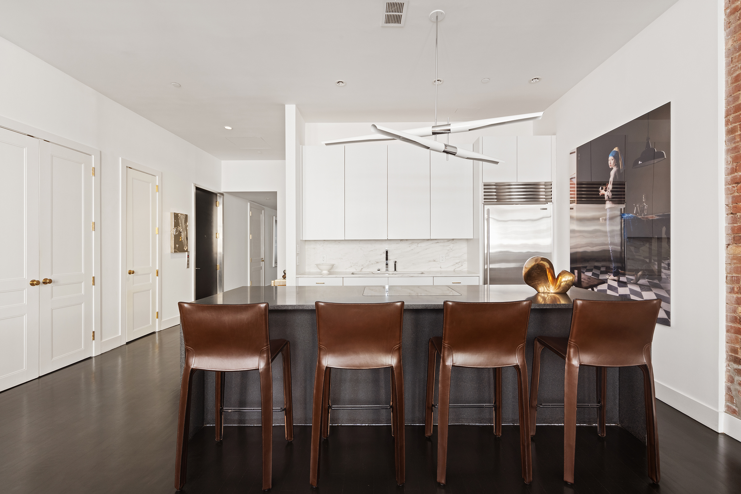 109 Greene Street, Unit 2C Manhattan, NY 10012 - Photo 3 of 13 a kitchen with granite countertop a table chairs stove and white cabinets