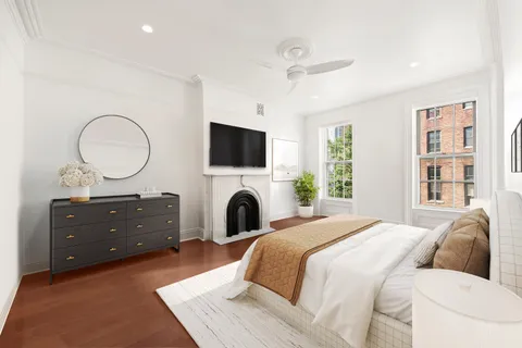 a spacious bedroom with a bed and a mirror on the dresser