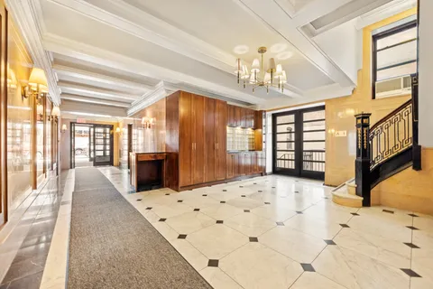 a large bedroom with wooden floor and chandelier