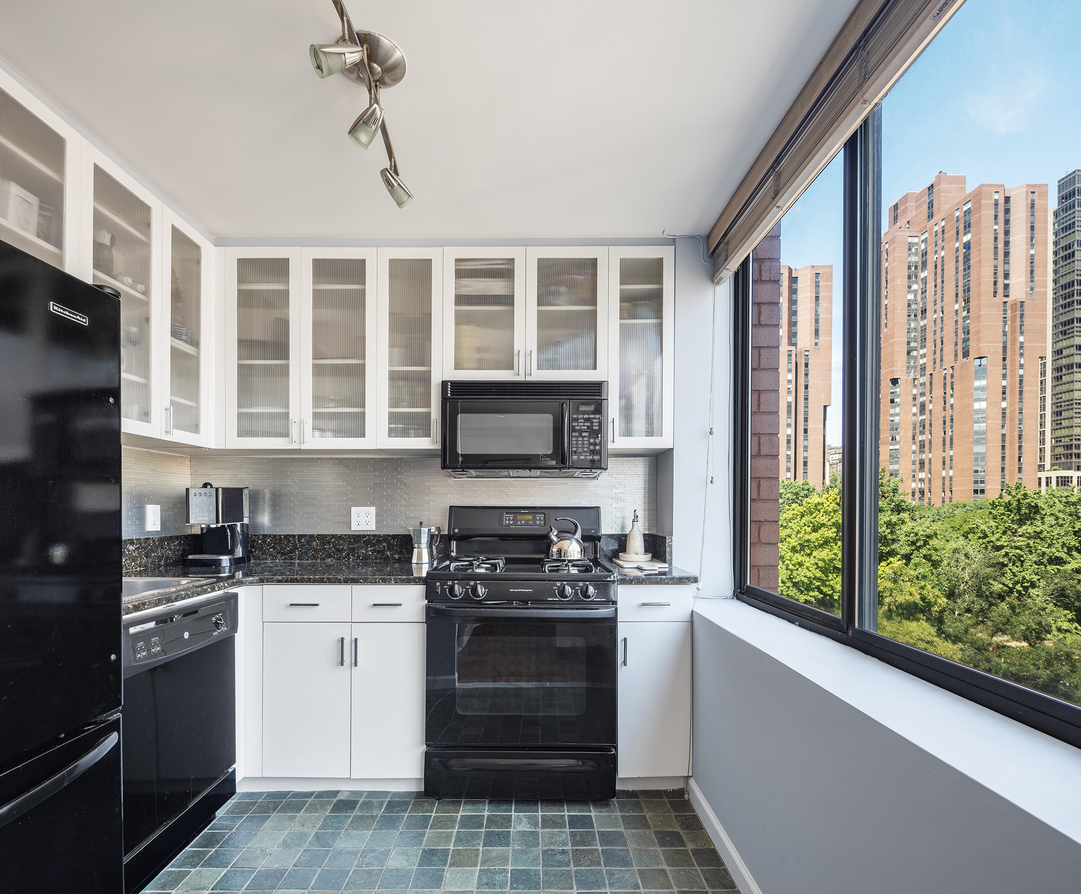 300 East 90th Street, Unit 7C Manhattan, NY 10128 - Photo 2 of 12 a kitchen with a stove a sink and a microwave