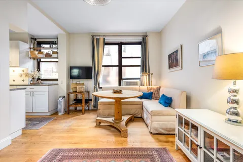 a living room with furniture a rug and a table
