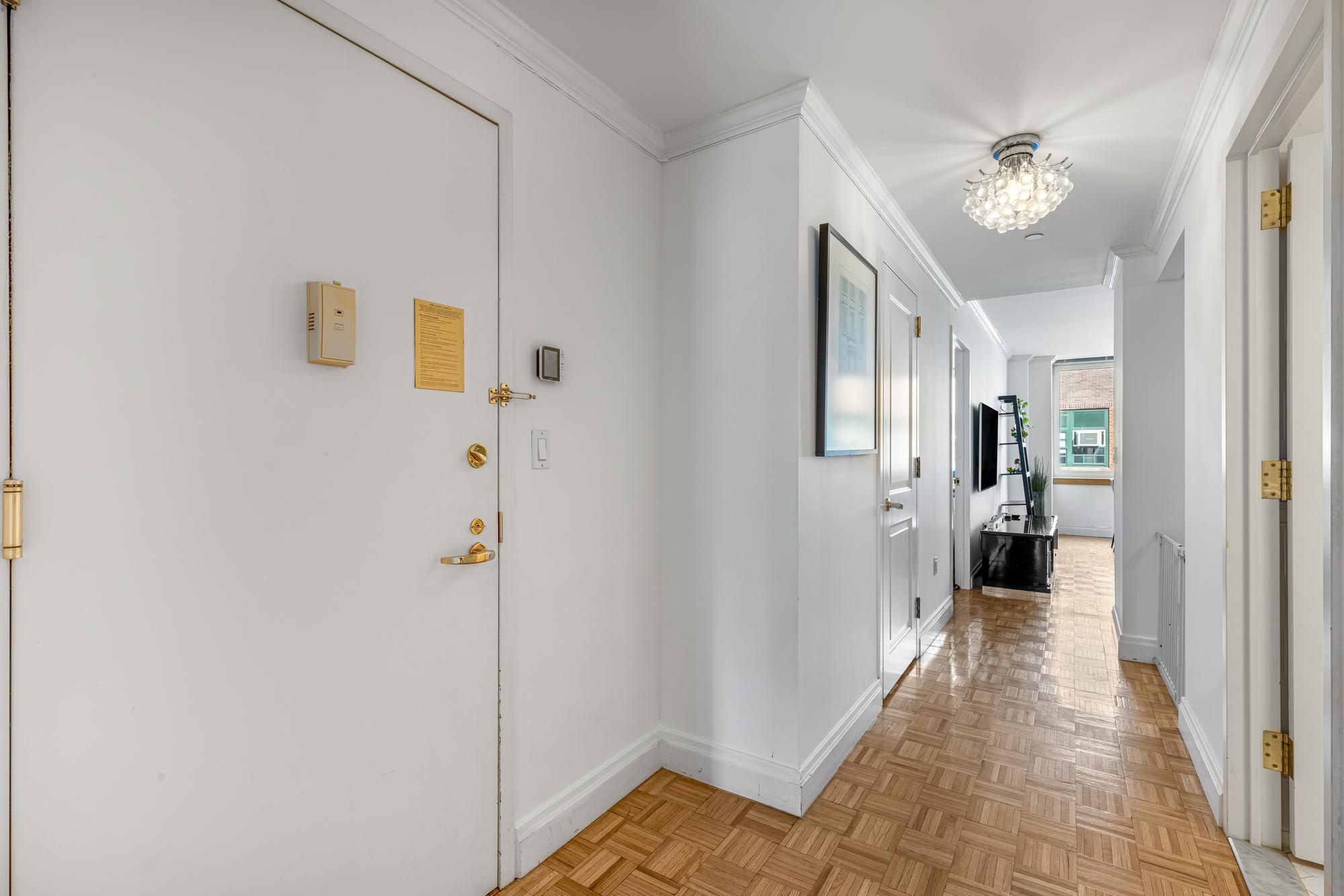404 East 76th Street, Unit 6K Manhattan, NY 10021 - Photo 9 of 12 a view of a hallway with a chandelier