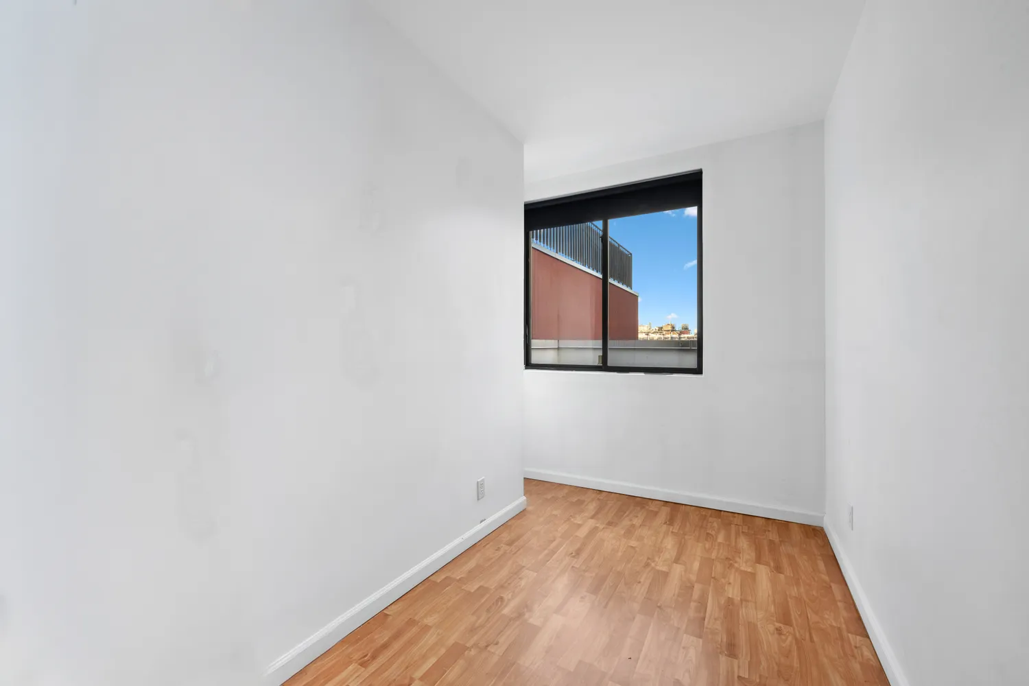 a view of a small space with wooden floor and a window
