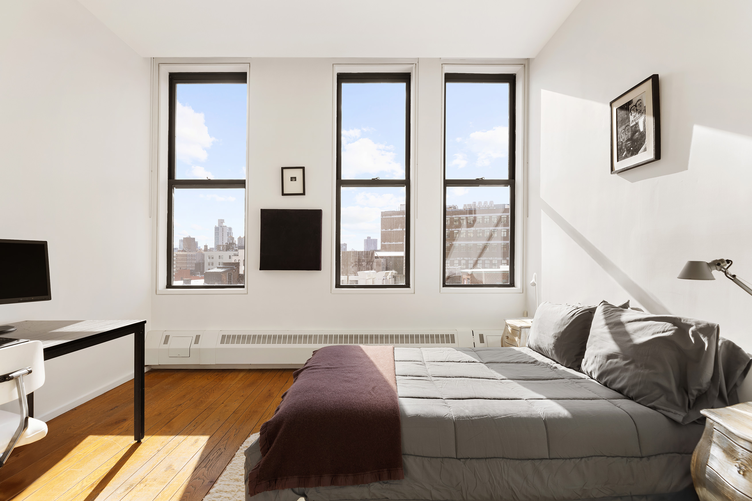 21 Astor Place, Unit 9E Manhattan, NY 10003 - Photo 7 of 10 a bedroom with a bed and wooden floor