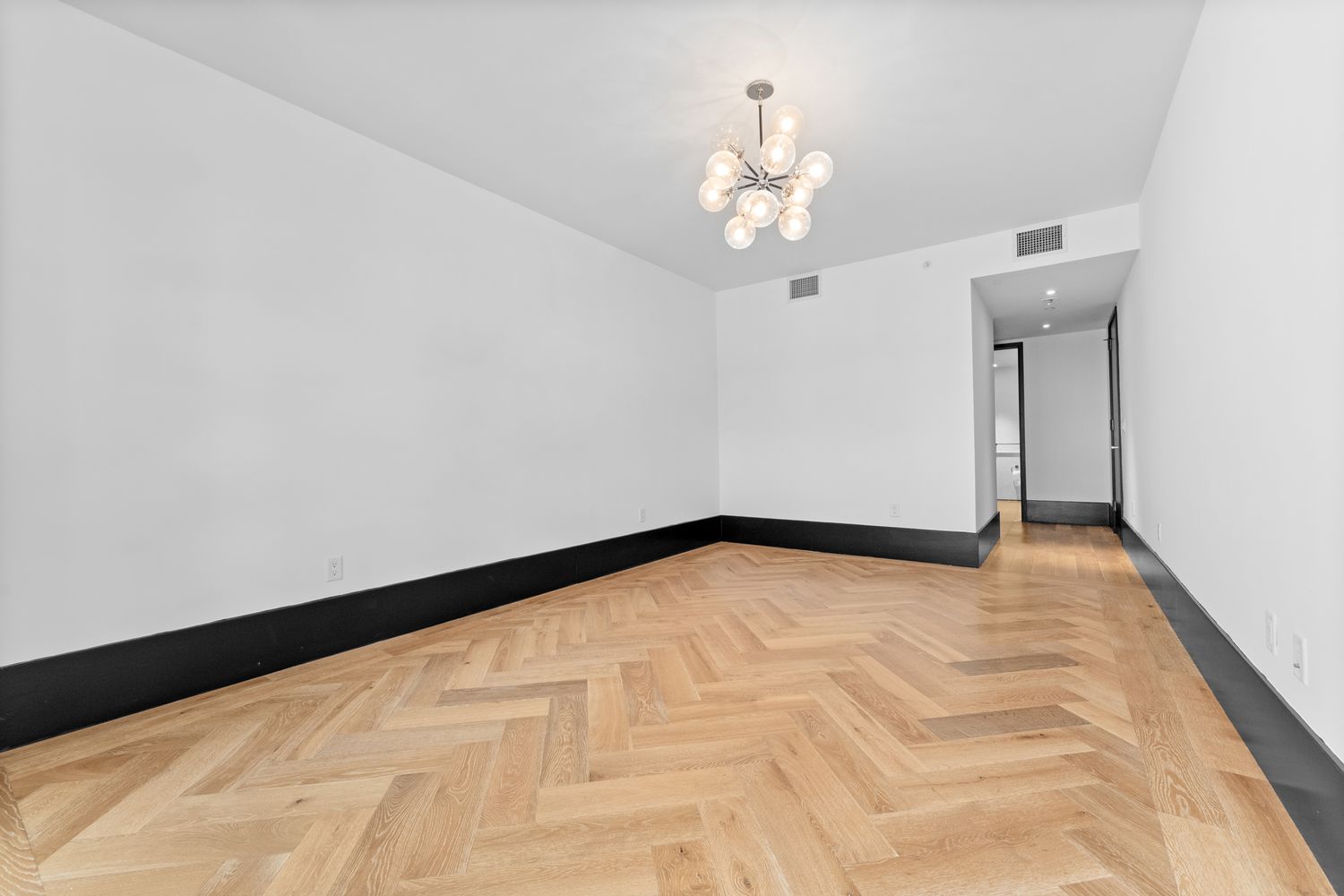 a view of empty room with wooden floor