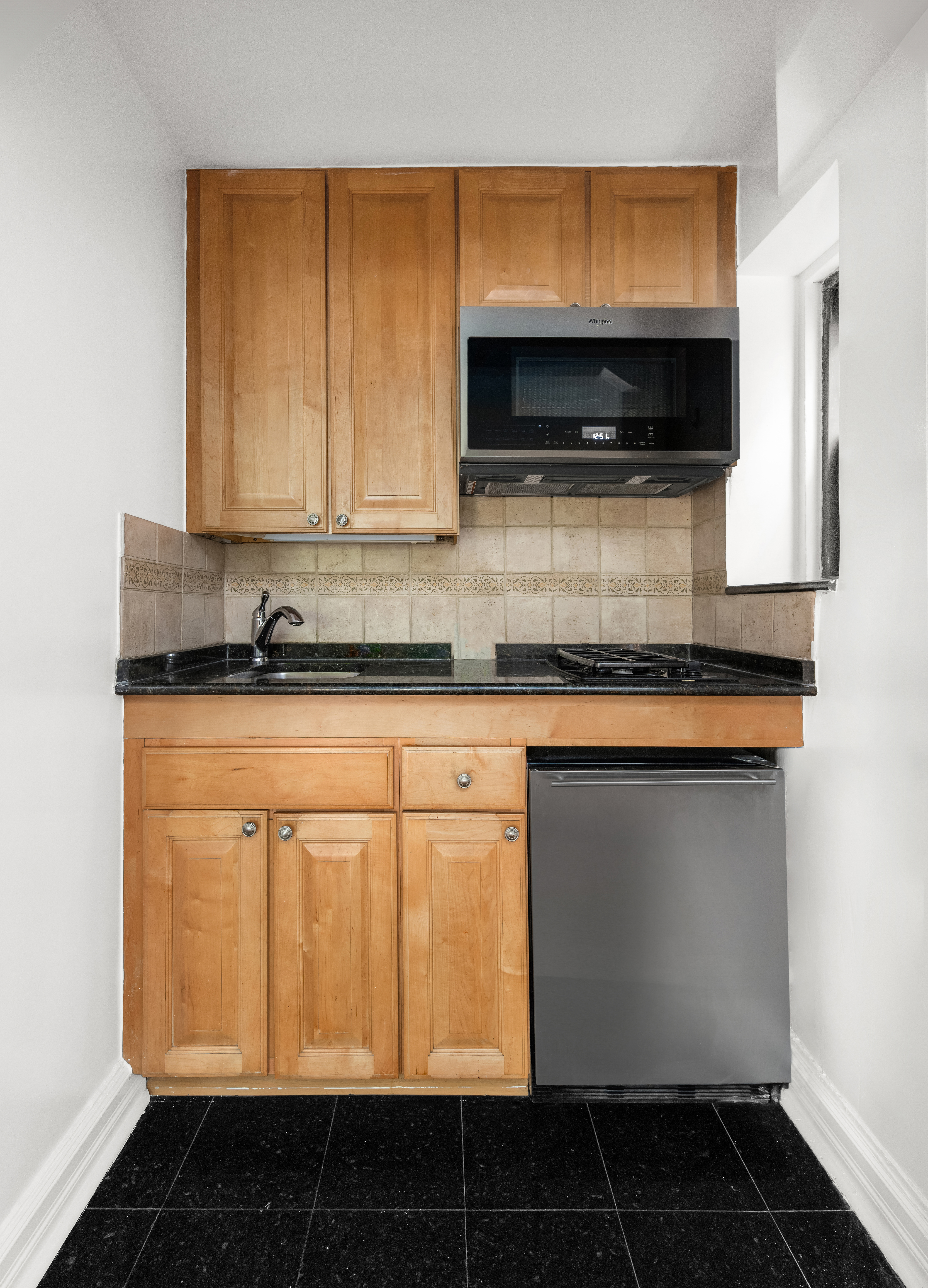 436 East 58th Street, Unit 1C Manhattan, NY 10022 - Photo 8 of 14 a kitchen with a sink and a microwave