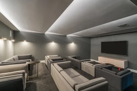 a media room with lots of chairs and a projector screen