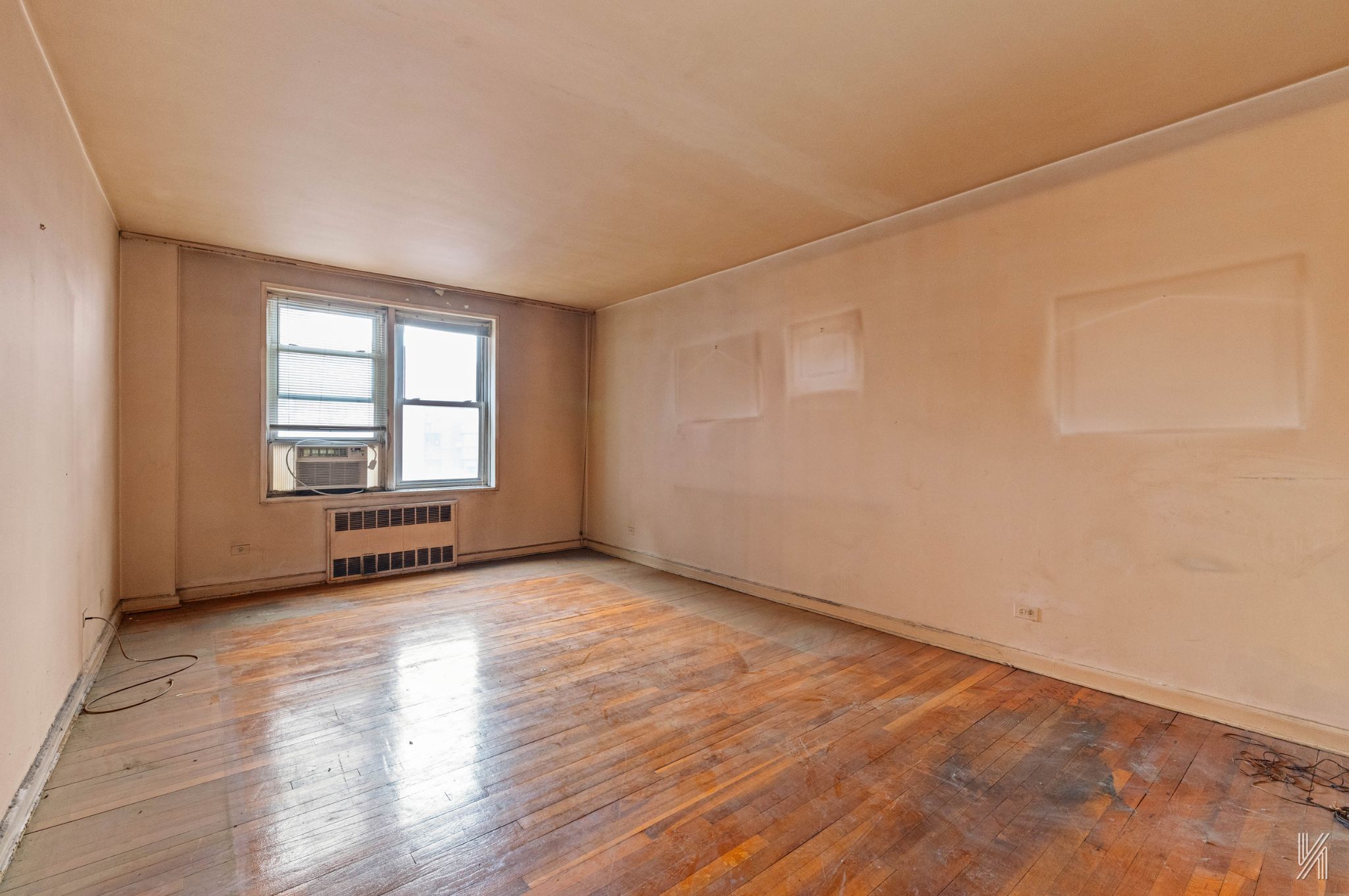 33-05 90th Street, Unit 4F Queens, NY 11372 - Photo 2 of 18 an empty room with wooden floor and windows