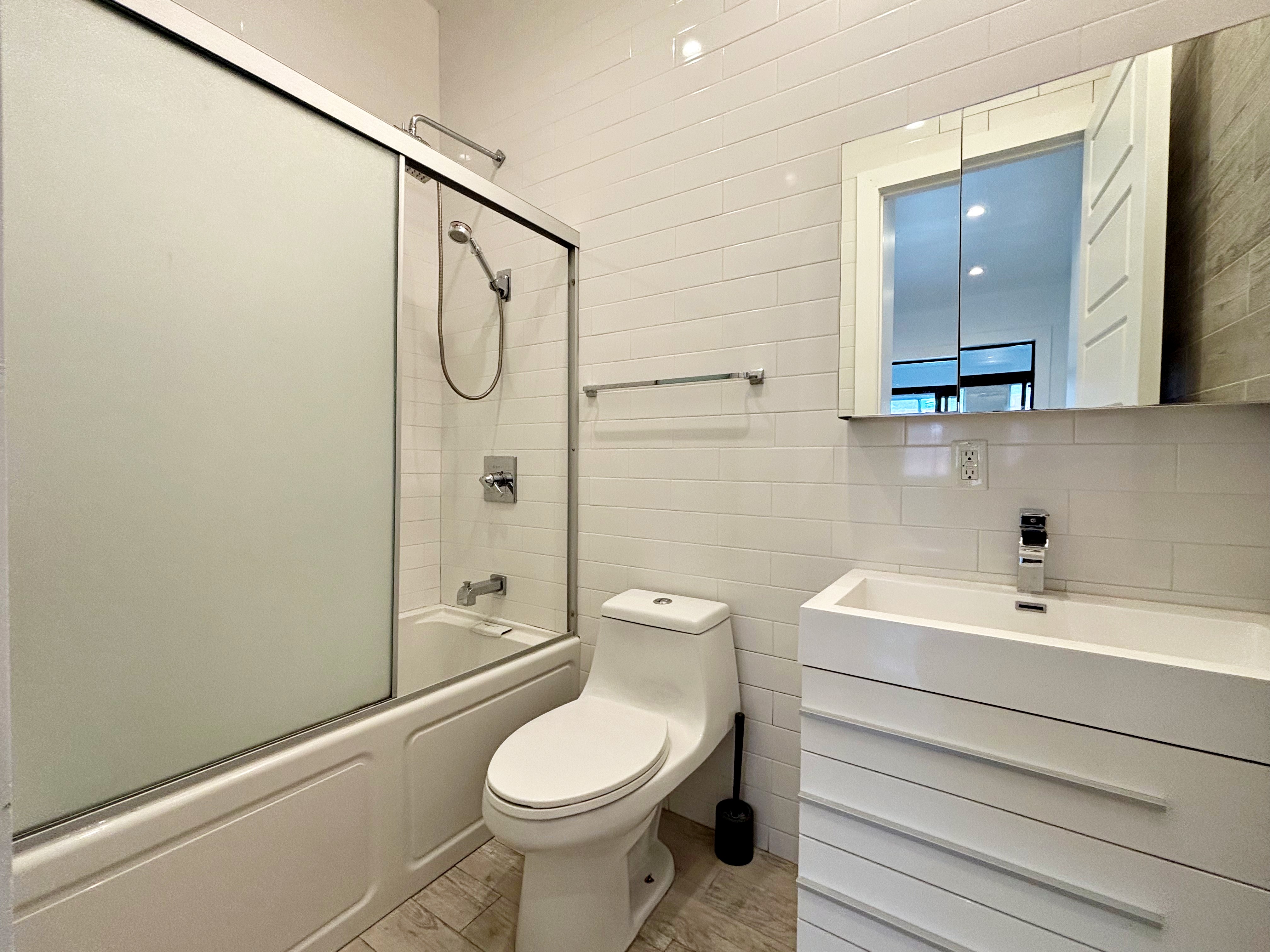 385 Nostrand Avenue, Unit Undisclosed Brooklyn, NY 11216 - Photo 23 of 27 a bathroom with a sink a toilet and shower