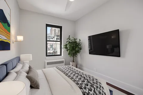 a bedroom with a bed and a flat screen tv