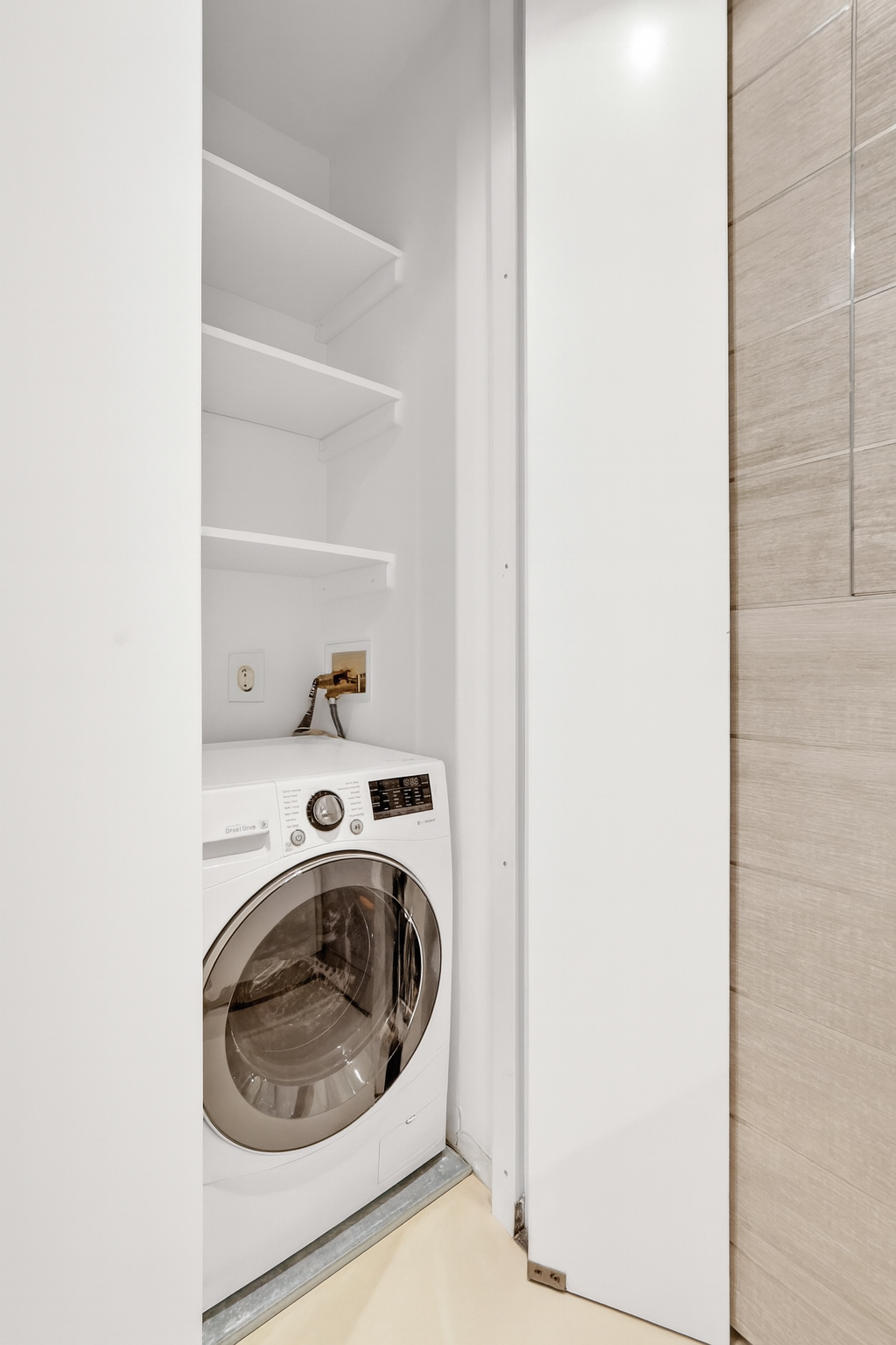 117 East 57th Street, Unit 20F Manhattan, NY 10022 - Photo 10 of 18 a utility room with washing machine