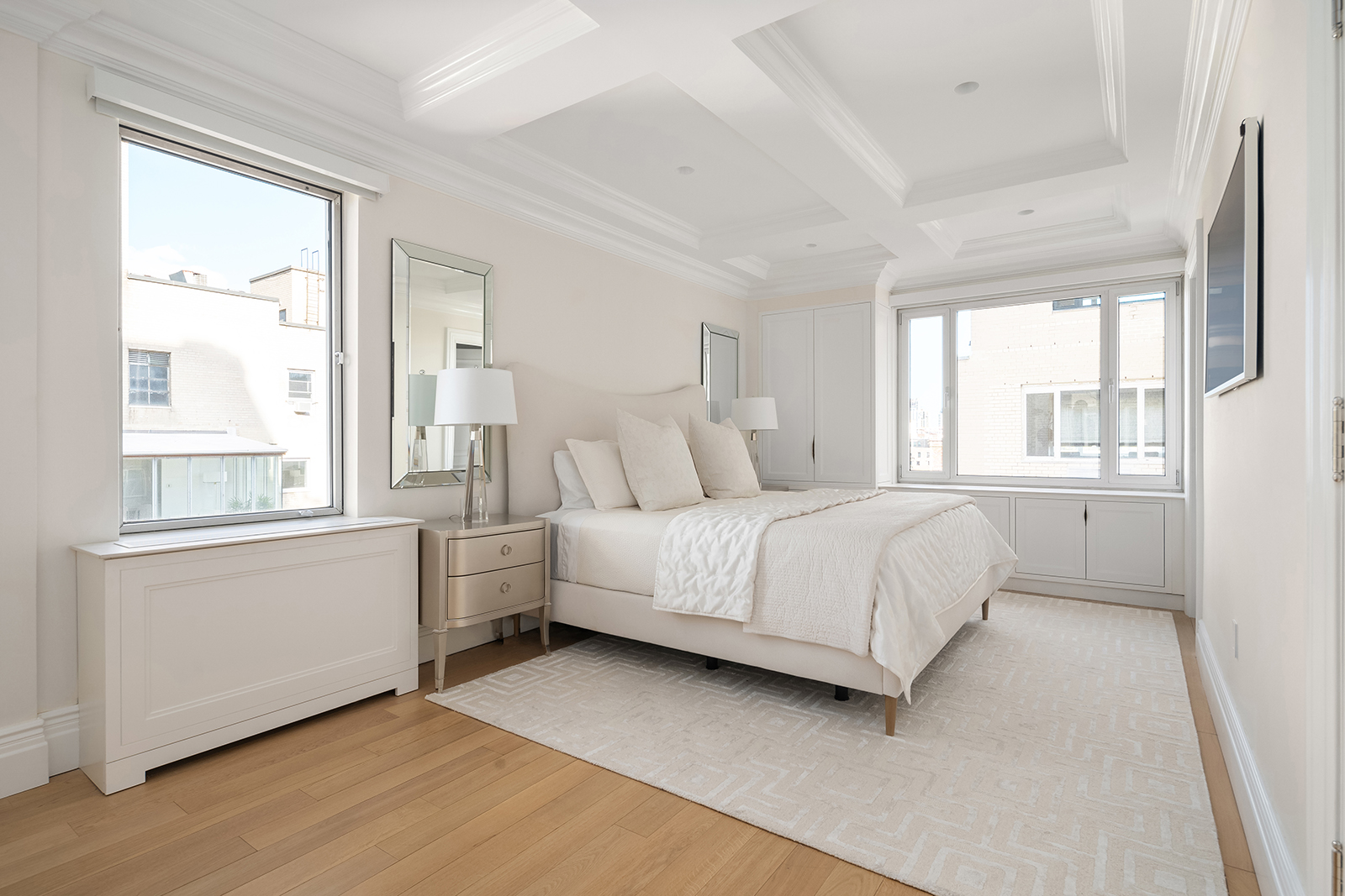 930 5th Avenue, Unit 18A Manhattan, NY 10021 - Photo 10 of 16 a bedroom with a white bed and a large window