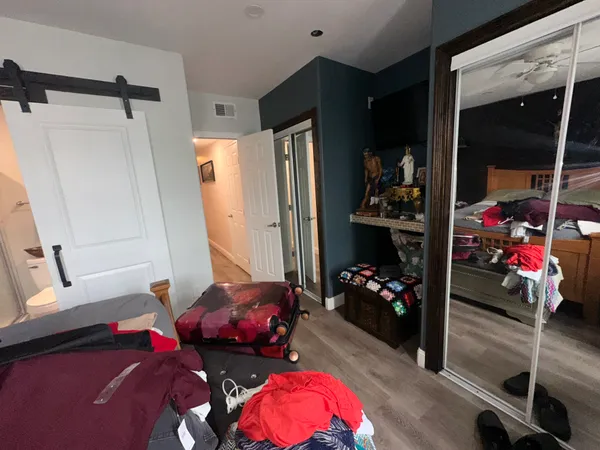 a bedroom with bed and a mirror