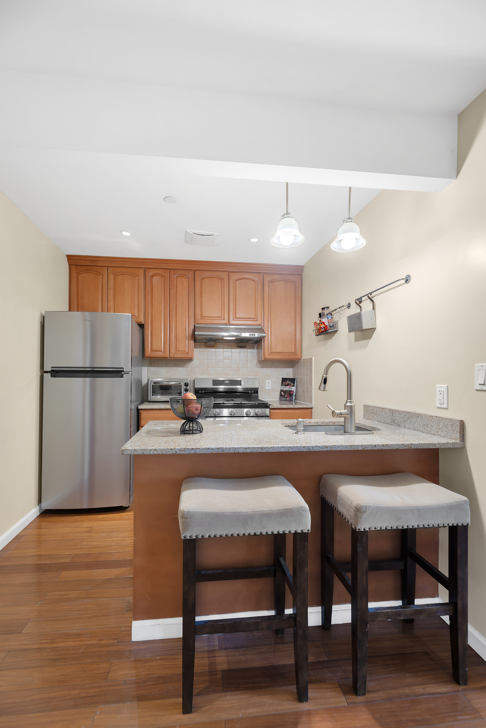 43-33 42nd Street, Unit 6B Queens, NY 11104 - Photo 5 of 8 a kitchen with a table chairs refrigerator and cabinets