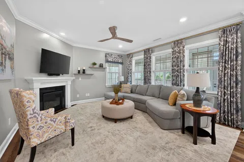 a living room with furniture a flat screen tv and a fireplace