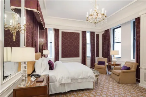 a bedroom with a large bed and a chandelier
