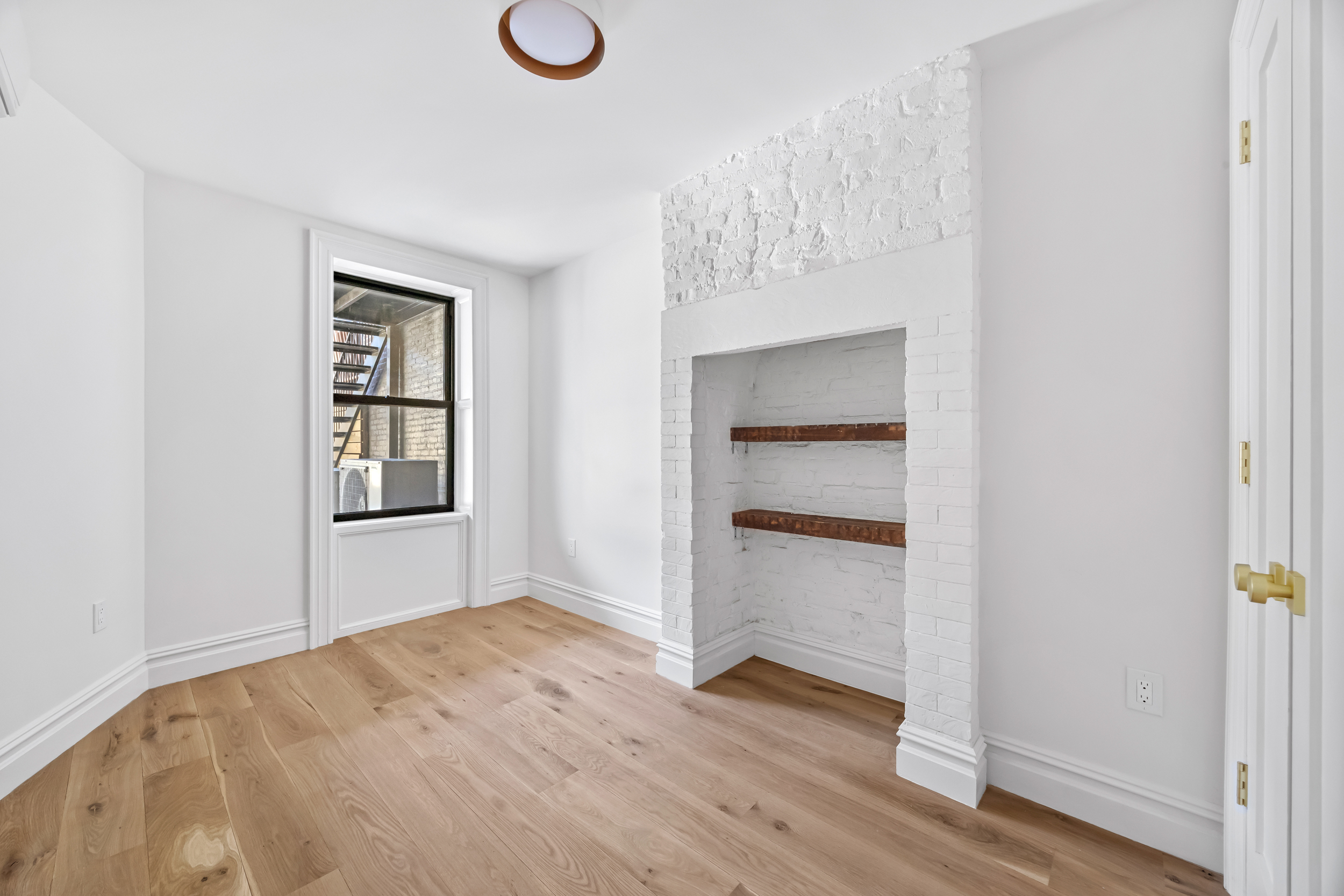 544 Madison Street, Unit A Brooklyn, NY 11221 - Photo 13 of 17 a view of an empty room with a window and wooden floor