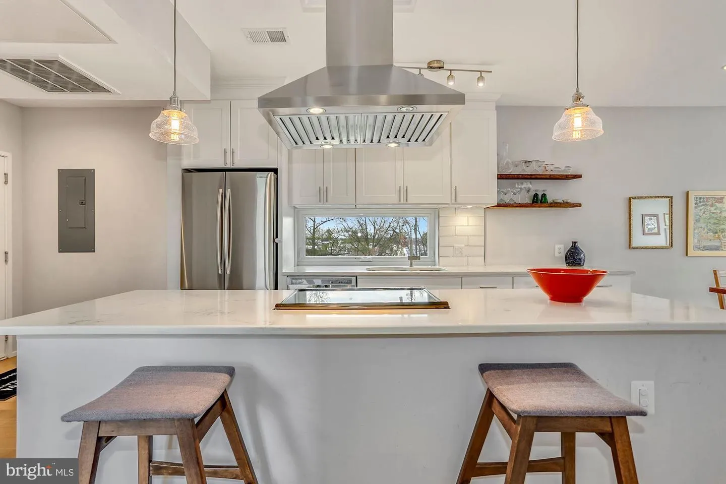 a room with kitchen island a sink dishwasher a stove a dining table and chairs with wooden floor