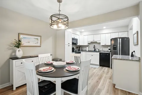 a kitchen with stainless steel appliances kitchen island granite countertop a dining table and chairs