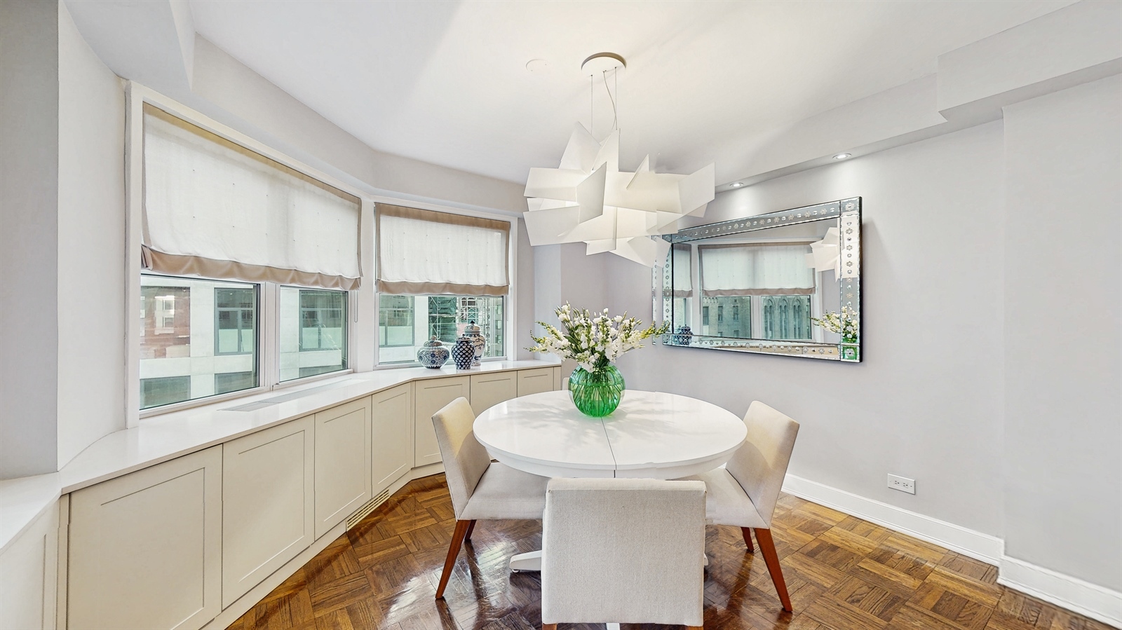 136 East 56th Street, Unit 16B Manhattan, NY 10022 - Photo 4 of 11 a view of a dining room with furniture window and wooden floor