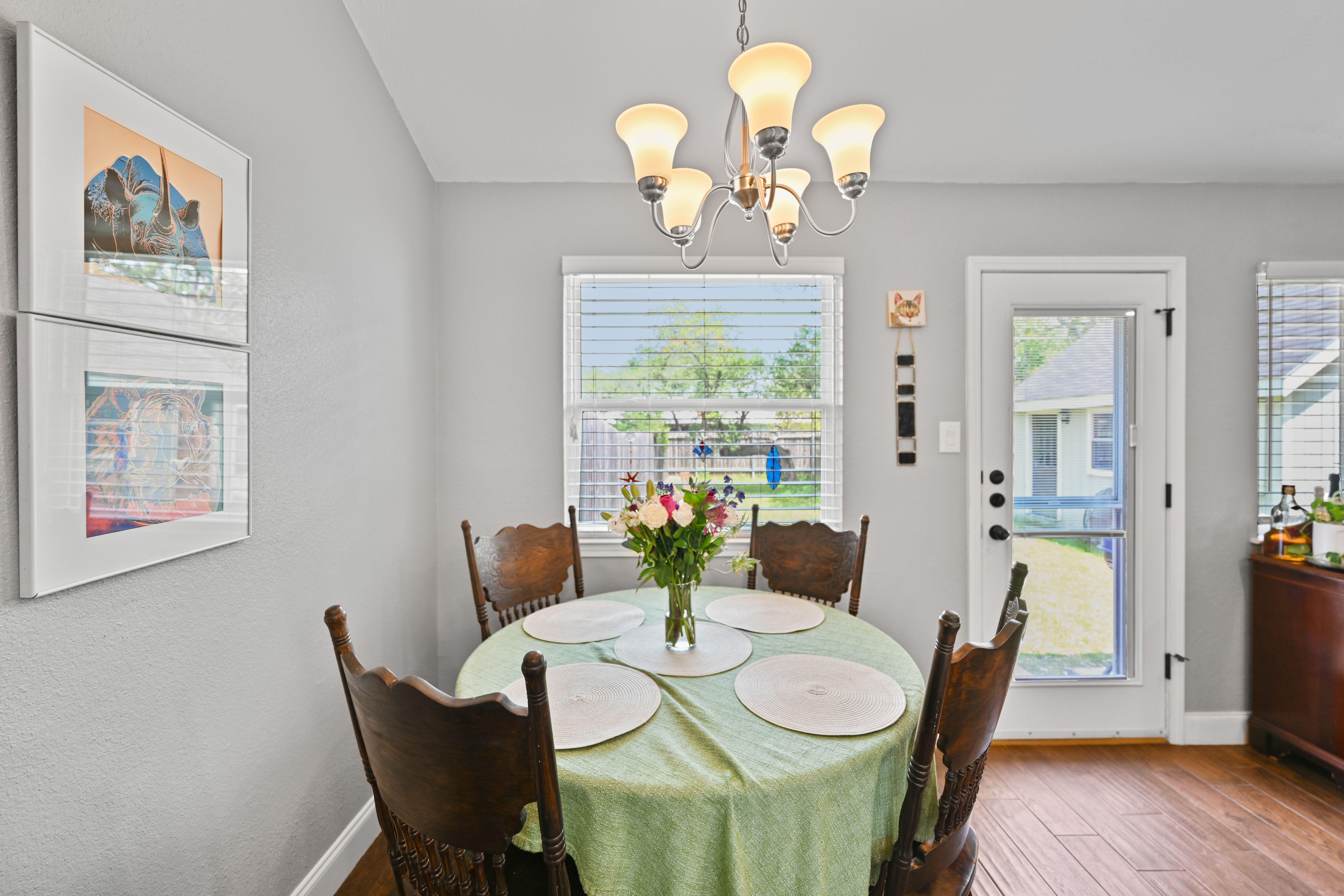 8710 Clearbrook Trail Austin, TX 78729 - Photo 7 of 28 a view of a dining room with furniture a chandelier and wooden floor