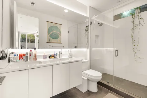 a bathroom with a toilet sink a mirror and shower
