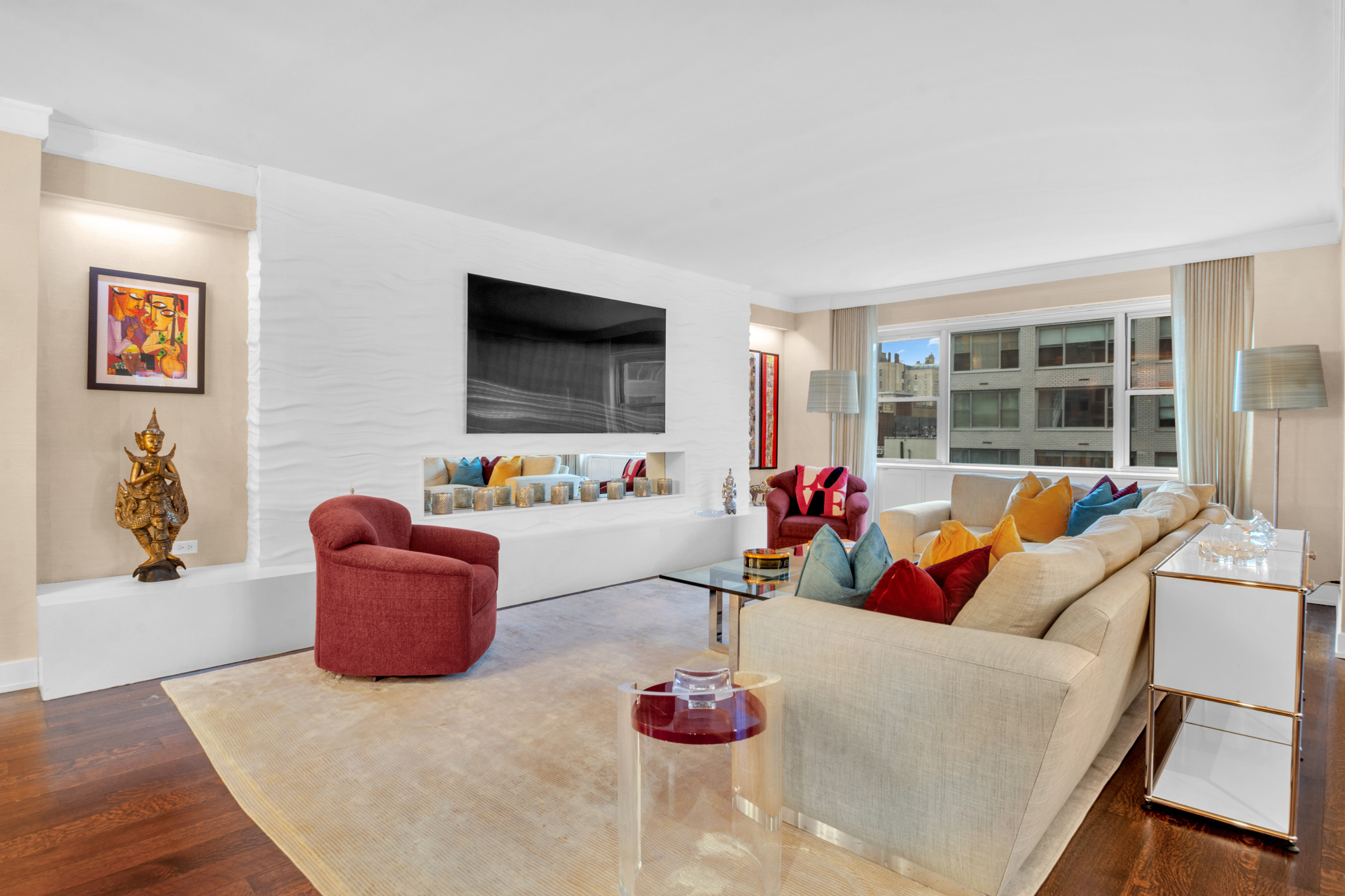 150 East 69th Street, Unit 6Q Manhattan, NY 10021 - Photo 3 of 15 a living room with furniture potted plant and a flat screen tv
