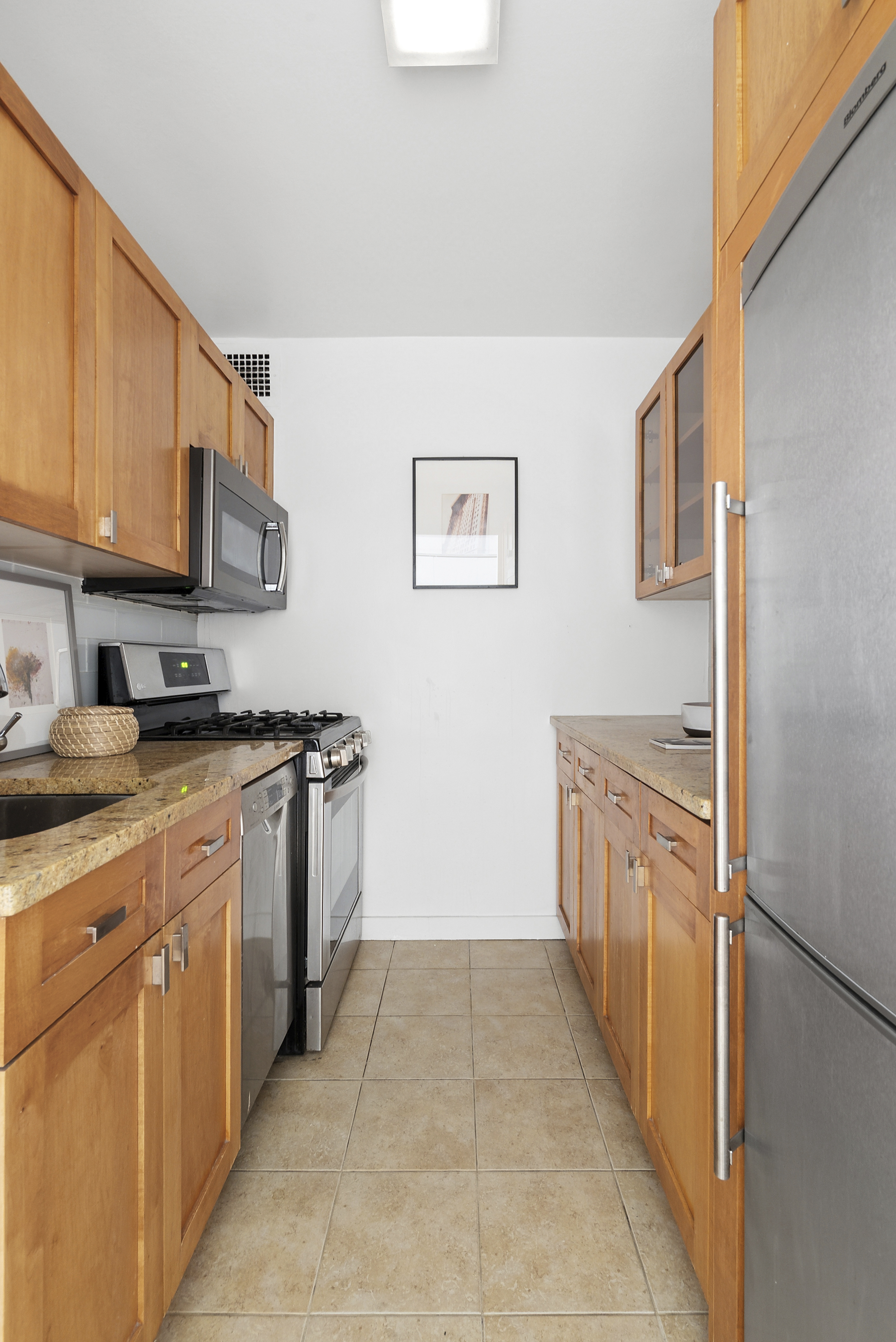 165 West End Avenue, Unit 11A Manhattan, NY 10023 - Photo 2 of 5 a kitchen with stainless steel appliances granite countertop a stove a sink and a refrigerator