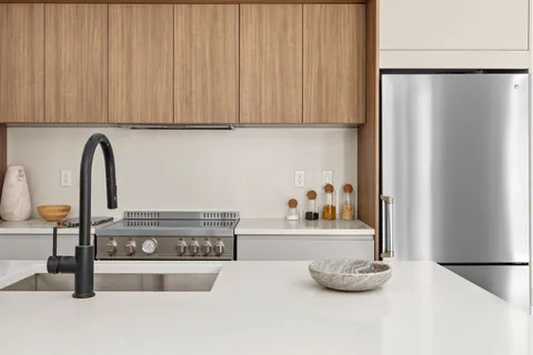 a view of a kitchen with stainless steel appliances granite countertop a refrigerator and a stove