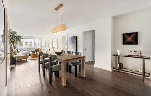a living room with furniture a wooden floor and a flat screen tv