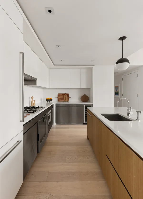 a large kitchen with stainless steel appliances lots of counter space and a sink