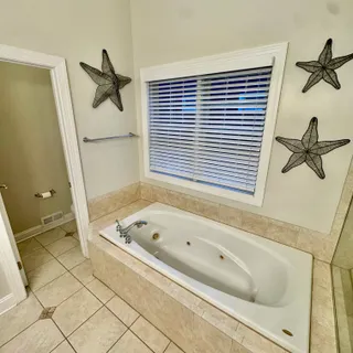 a spacious bedroom with a bed and a painting on the wall