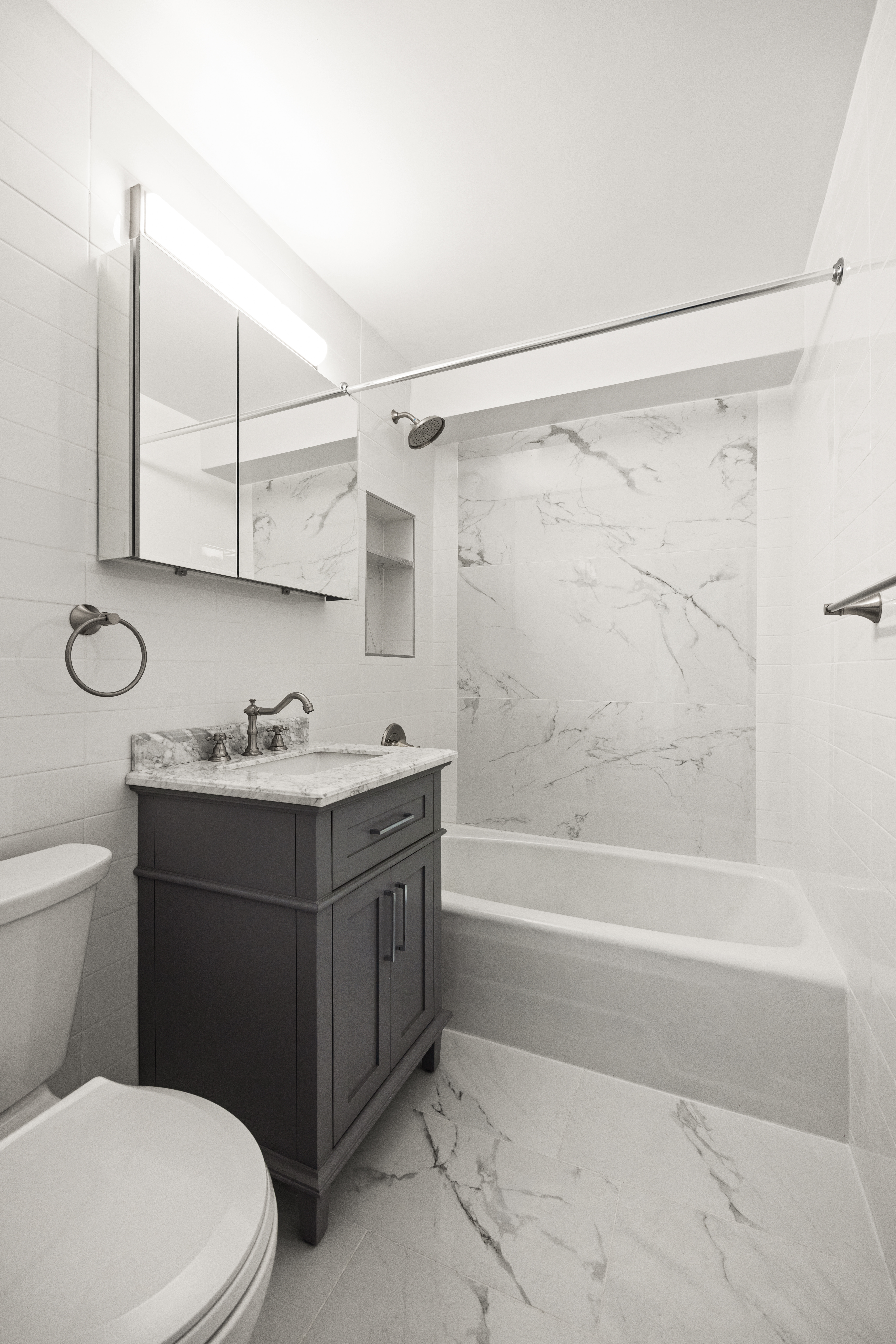135 Ocean Parkway, Unit 16N Brooklyn, NY 11218 - Photo 12 of 16 a bathroom with a granite countertop bathtub shower sink mirror and toilet