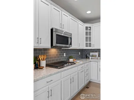 a kitchen with stainless steel appliances kitchen island granite countertop a table chairs and a view of living room