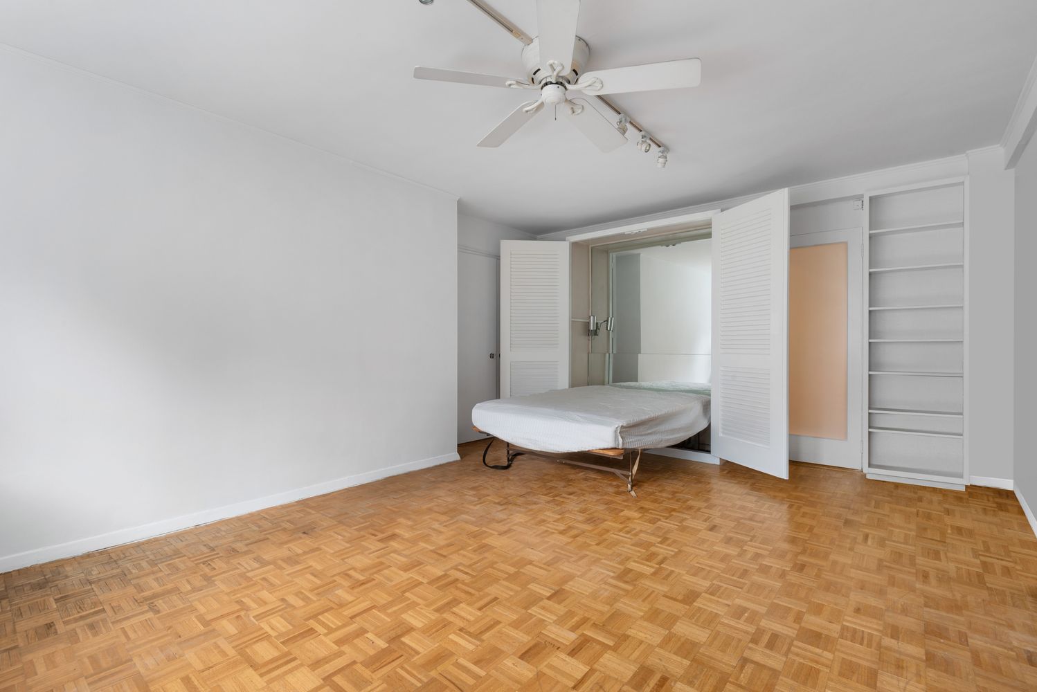 a view of a room with a ceiling fan and wooden floor