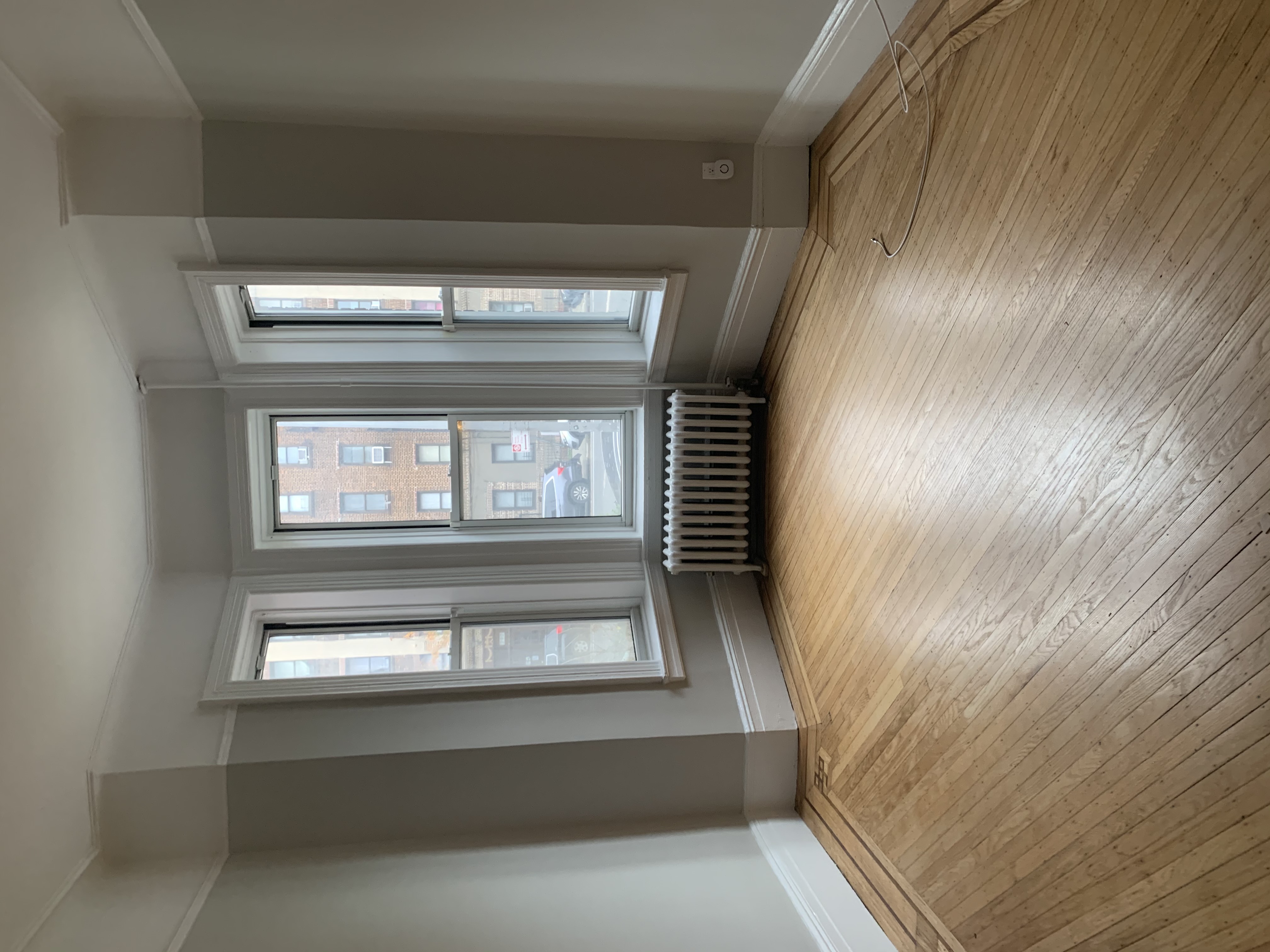 285 Empire Boulevard Brooklyn, NY 11225 - Photo 3 of 7 an empty room with wooden floor and windows