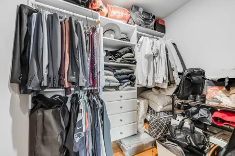 a view of walk in closet with clothes