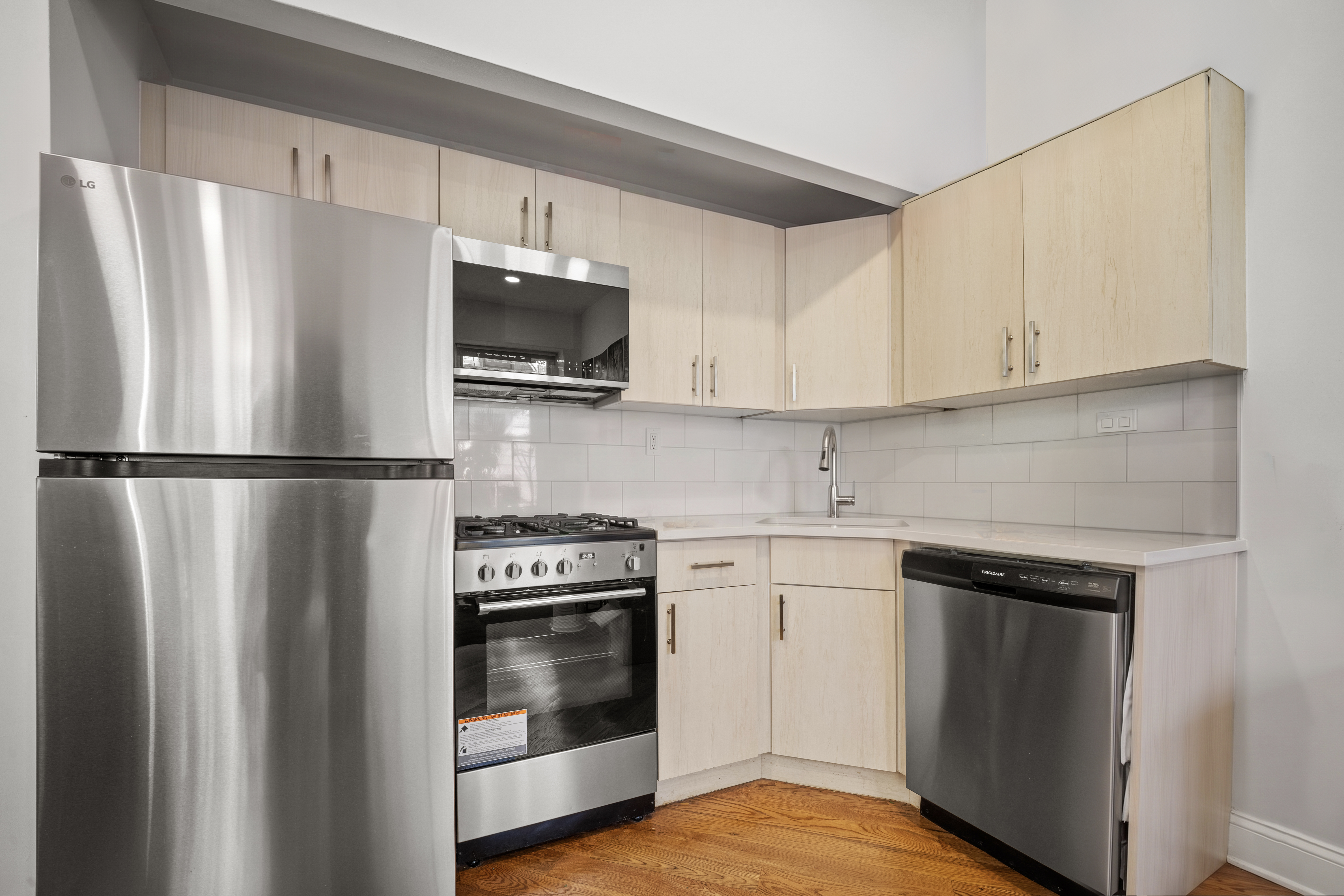 36 West 35th Street, Unit 2A Manhattan, NY 10001 - Photo 7 of 11 a kitchen with stainless steel appliances a refrigerator stove and microwave