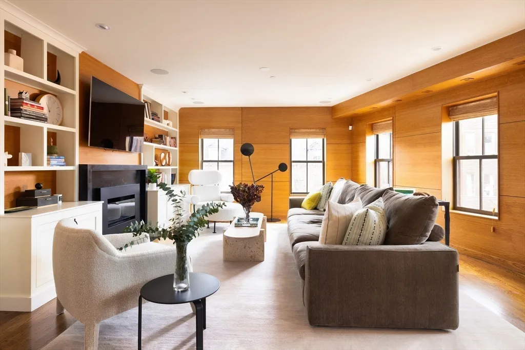 a living room with fireplace furniture and a large window