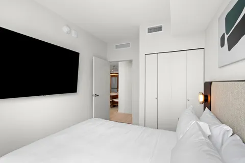 a bedroom with a bed and a flat screen tv