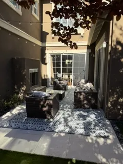 a view of a backyard with table and chairs potted plants and wooden fence