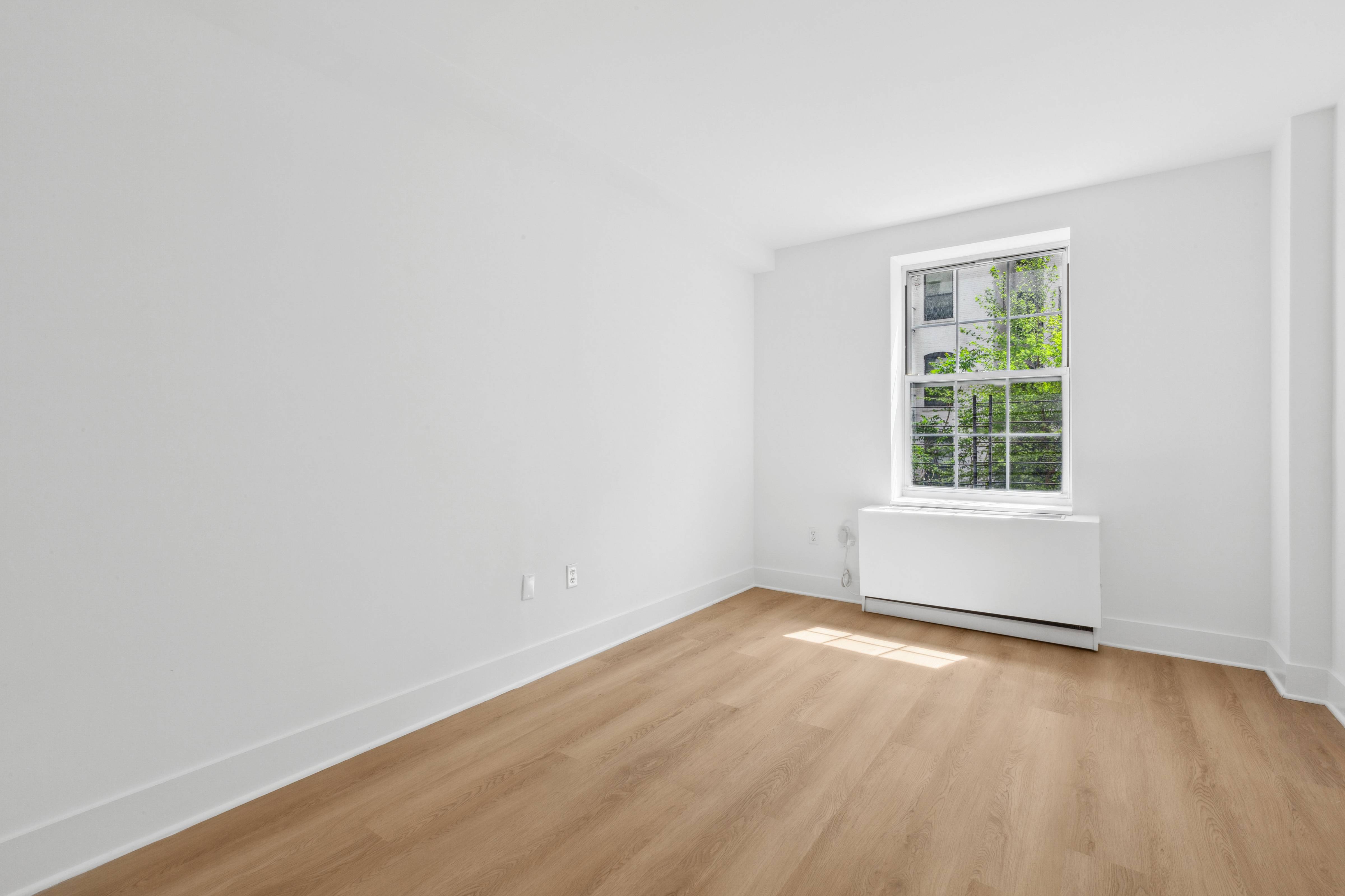 266 West 115th Street, Unit 2B Manhattan, NY 10026 - Photo 8 of 11 an empty room with wooden floor and windows