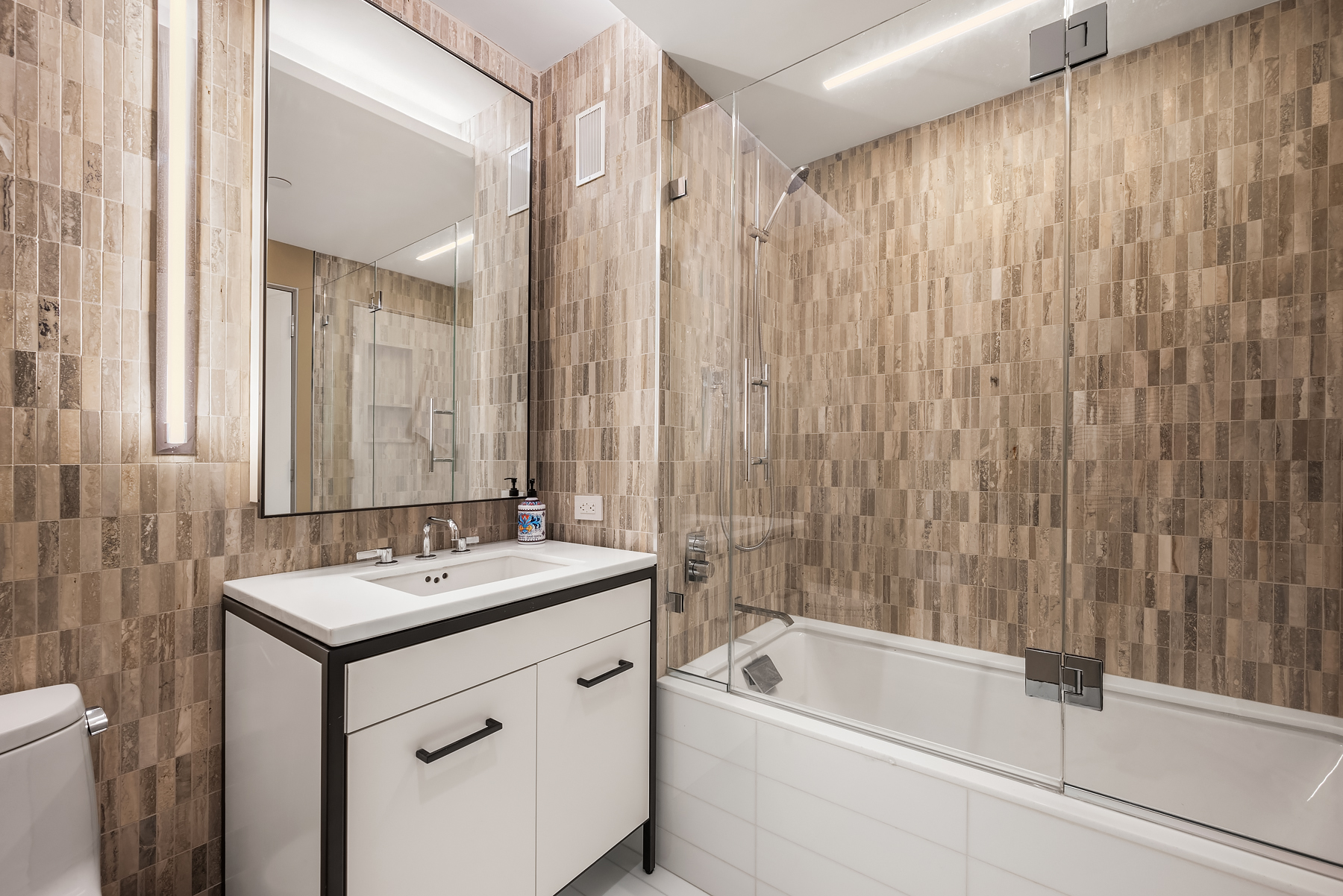 70 Charlton Street, Unit 11A Manhattan, NY 10014 - Photo 15 of 22 a bathroom with a tub sink shower and a mirror